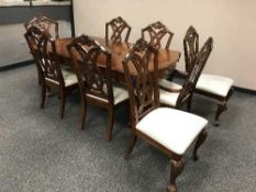 A contemporary mahogany extending dining table with three leaves together with a set of eight