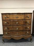 A continental oak serpentine fronted chest of four drawers on pad feet