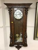 An oak wall clock with enamelled dial