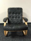A late 20th century beech framed armchair in black button leather