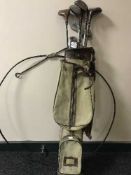 A metal hoop and a golf bag with hickory shafted drivers and Walter Glover irons