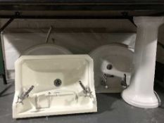 Three ceramic bathroom sinks with taps,