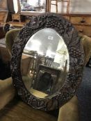 An antique heavily carved oak framed mirror