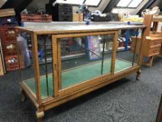 An early 20th century oak framed shop display cabinet