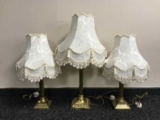 Three brass Corinthian column table lamps with shades