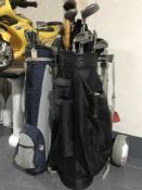 Three golf bags and assorted golf clubs with two folding trolleys