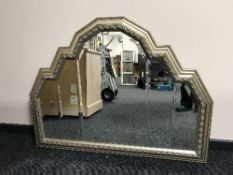 A shaped gilt framed sectional over mantel mirror
