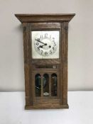 An Edwardian oak wall clock with calendar dial