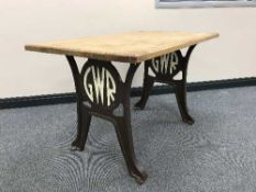 An oak topped kitchen centre table on cast iron legs bearing the initials GWR