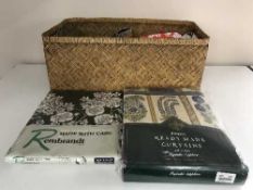 A basket and box of assorted table linen, curtains,