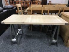 An industrial style oak low table on polished steel support,