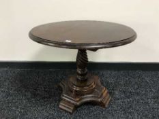 A small oak circular coffee table on pedestal base