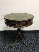 A circular leather topped drum table