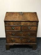 An inlaid mahogany Georgian bureau on bracket feet