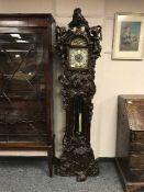 An ornate Art Nouveau style longcase clock with brass and enamel dial