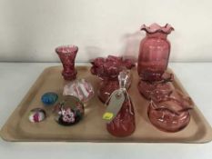 A tray of seven pieces of cranberry glass and four glass paperweights