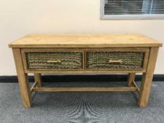 A reclaimed pine side table with three wicker drawers