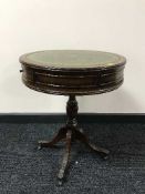 A mahogany leather topped drum table