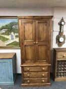 A pine double door wardrobe fitted with three drawers