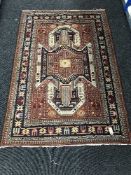A fringed woolen Eastern rug on red ground and two table lamps