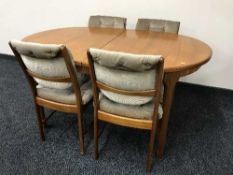 A late 20th century teak extending dining table and four chairs