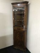 A mahogany glazed door corner cabinet