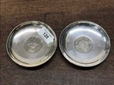 A matched pair of silver dishes with inset coins, diameter 10.