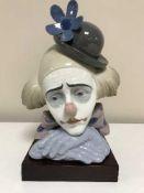 A Lladro bust of a clown on wooden base