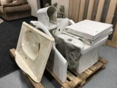 A pallet of two toilets, cisterns and seats,