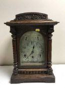 A carved oak chiming bracket clock with silvered dial