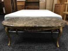A gilt wood oval coffee table with marble top