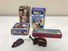 A basket containing five tin plate wind up toys including boxed bear with flash camera,
