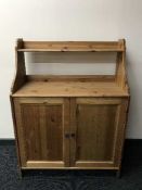 A pine cabinet fitted a shelf above