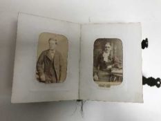 An antique tortoise shell photo album containing black and white photos