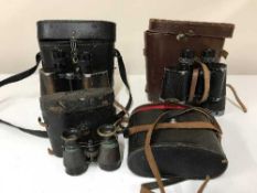 A basket of four sets of cased binoculars and field glasses
