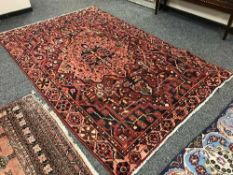 A Persian Heriz carpet on red ground 300 cm x 190 cm
