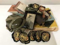 A tray of military badges, belts, leather holster, canteen, ration book,