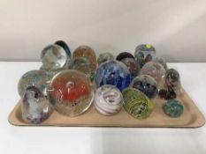 A tray of twenty one assorted glass paperweights