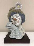 A Lladro clown with hands clasped,