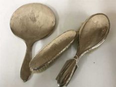 A three piece silver backed brush set