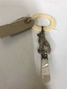 A silver and mother of pearl child's rattle in the form of a dog