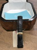 A black leather watch strap with 18ct gold buckle, together with a burr walnut finished watch box.