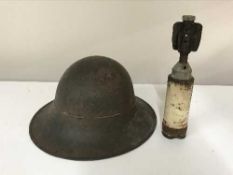 An artillery shell casing and a tin helmet