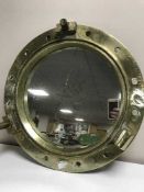 A circular brass port hole mirror