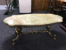 A shaped onyx coffee table on a gilt metal base