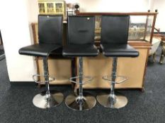 A set of three contemporary gas lift bar stools