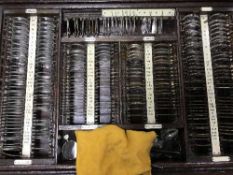 An early 20th century oak glazed top cabinet containing optometrists lenses