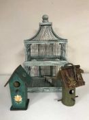 A decorative bird cage and two wooden bird boxes