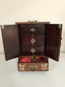 A mahogany mother of pearl inlaid oriental miniature cabinet