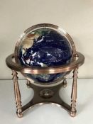 A large gem stone globe on metal stand